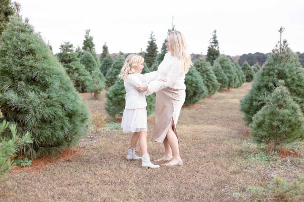 A Mother and daughter wearing cream and champagne colors play together during a Christmas Mini Session in Virginia Beach by Mary Eleanor Photography.