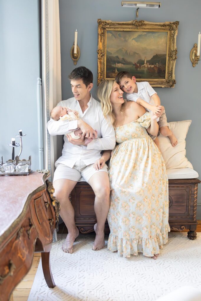 Mom and toddler playfully snuggle while Dad cradles newborn during newborn photos with Siblings at home by Mary Eleanor Photography.